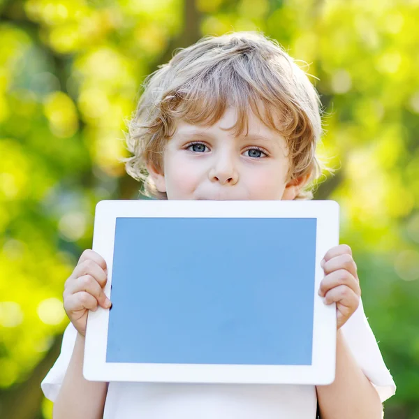 Rolig blond liten pojke håller TabletPC, — Stockfoto