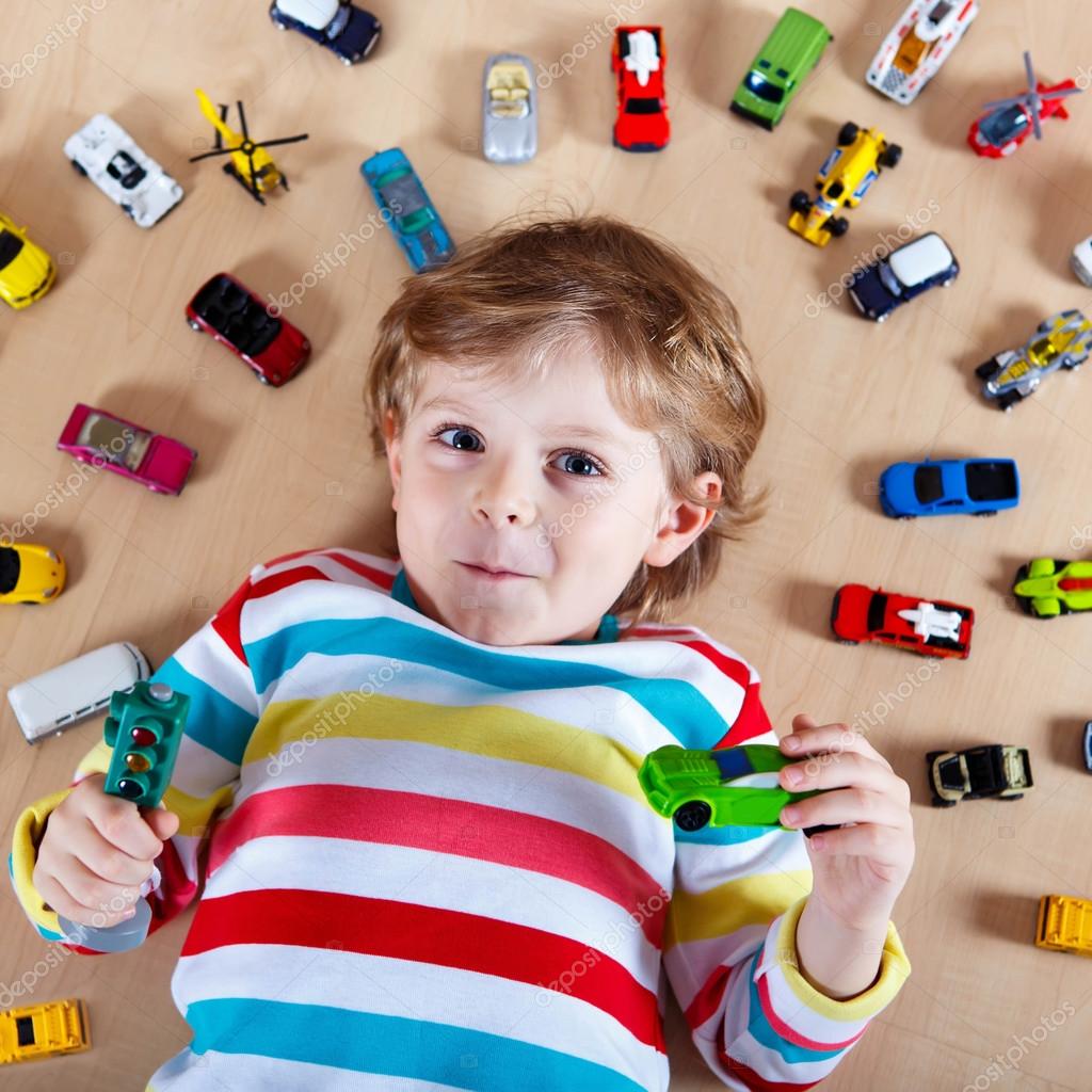niño jugando con carros