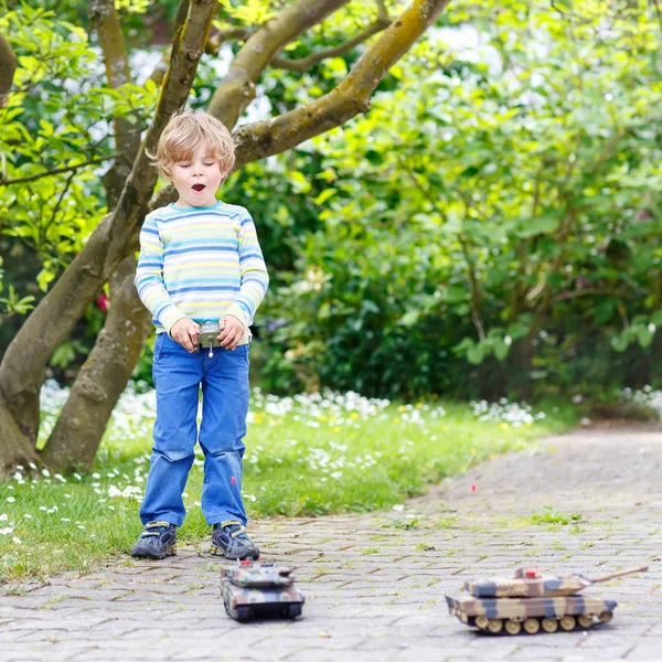 Bonito criança brincando com brinquedo tanque — Fotografia de Stock