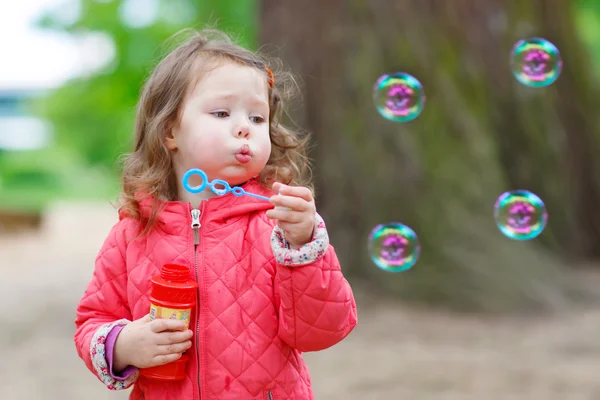 Menina bonito se divertindo com bolhas de sabão — Fotografia de Stock