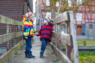 İki küçük çocuklar açık havada bahar şehirde çocuk