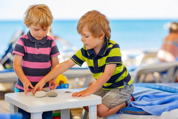 Two little kid boys playing on beach with stones — Stock Photo, Image
