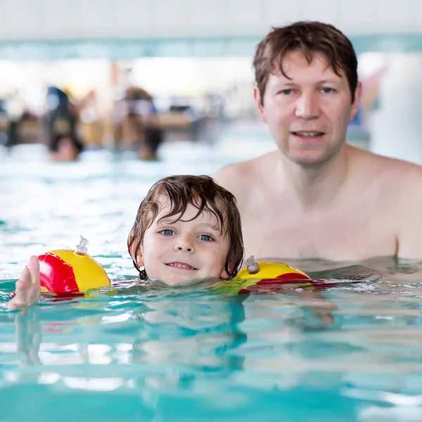 Маленький мальчик и его отец плавают в закрытом бассейне — стоковое фото