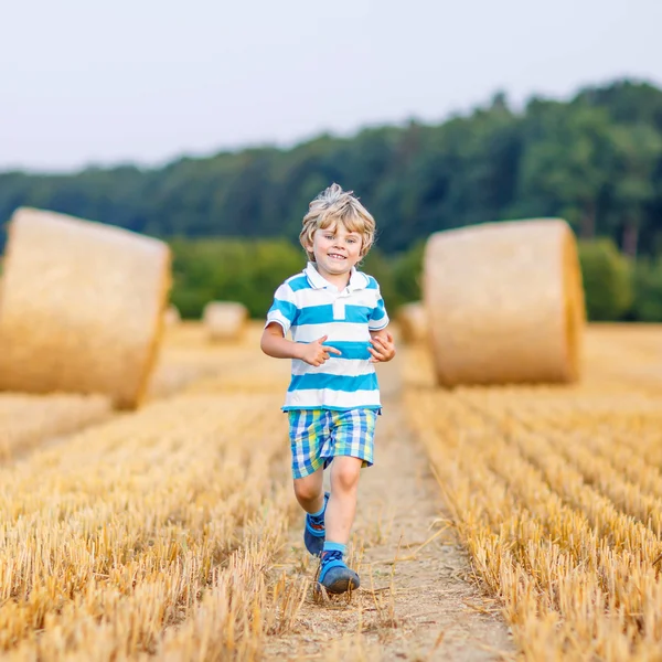 Little kid boy playing on hay field, outdoors — Stock Photo, Image