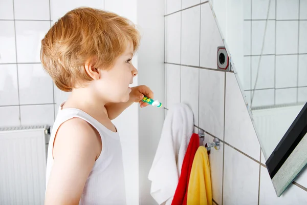 Precioso niño pequeño cepillándose los dientes, en el interior — Foto de Stock
