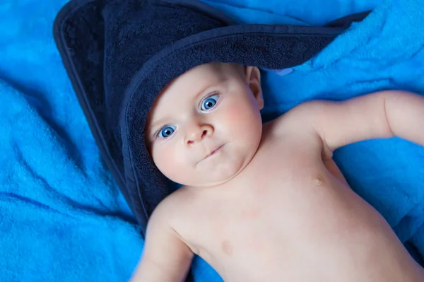 Menino menino pequeno contra a toalha de banho azul — Fotografia de Stock