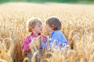 eğlenmek ve konuşan iki küçük kardeş erkek buğday sarı 