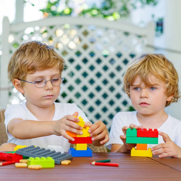 Two little kid boys playing with plastic blocks together — Stock Photo, Image