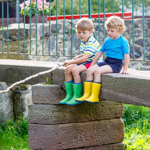 Två bedårande små vänner fiske med selfmade spö — Stockfoto