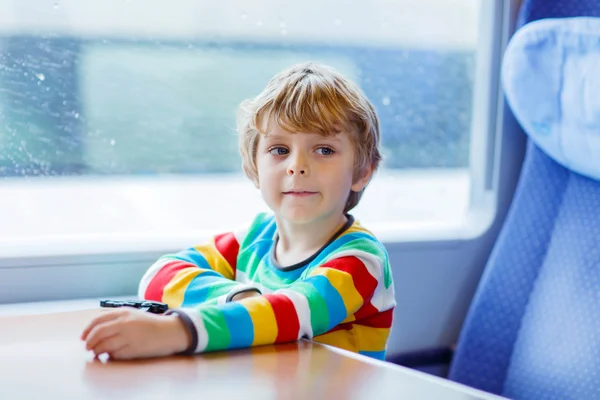 Little boy sitting in train and going on vacations — Zdjęcie stockowe