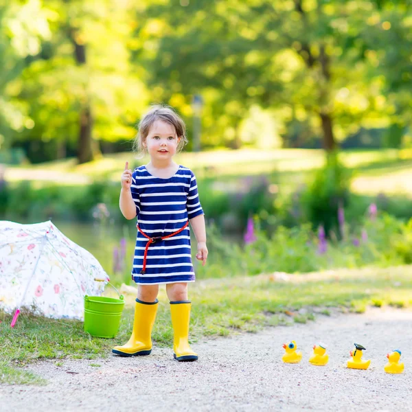 Petite fille jouant dans la forêt et portant des bottes — Photo