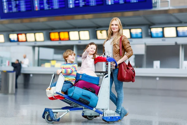 Mała dziewczynka i chłopiec i młody matka z walizki na lotnisko — Zdjęcie stockowe