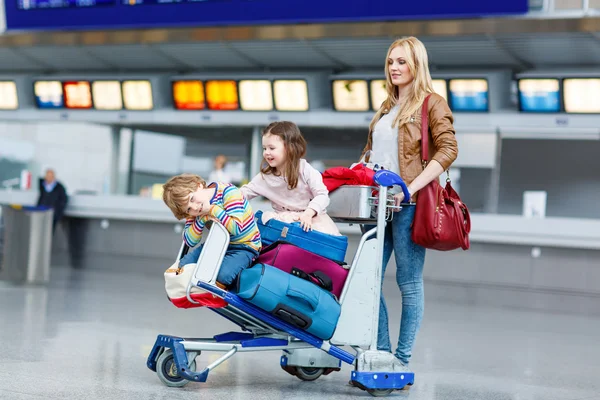Niña y niño y madre joven con maletas en el aeropuerto —  Fotos de Stock