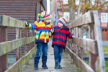 İki küçük çocuklar açık havada bahar şehirde çocuk