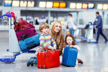 Küçük kız ve çocuk ve genç anne ile bavul Havaalanı