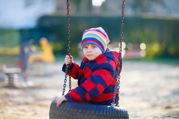 Kleiner Junge hat Spaß auf Kettenschaukel im Freien — Stockfoto