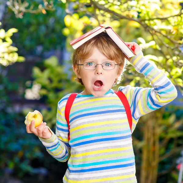 Маленький мальчик с яблоком по дороге в школу — стоковое фото