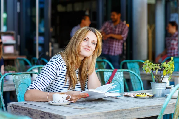 Mujer bebiendo café y leyendo libro en la cafetería —  Fotos de Stock