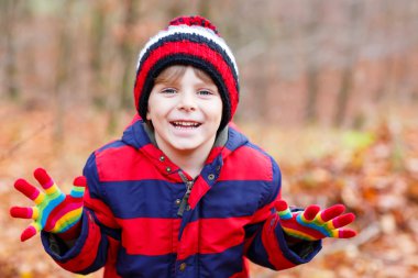 Sonbahar yaprakları arasında küçük şirin bir çocuk parkta..