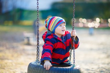 Açık havada zinciri salıncakta eğleniyor küçük çocuk çocuk