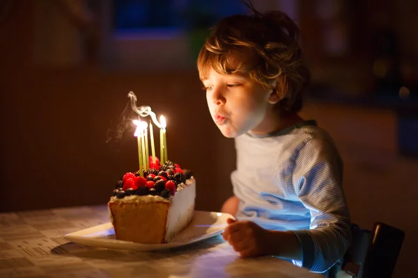 Kleine jongen jongen blazen kaarsen op de verjaardagstaart — Stockfoto