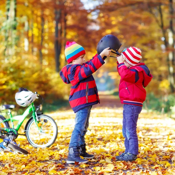 Två kid lite pojkar med cyklar i höst skog — Stockfoto