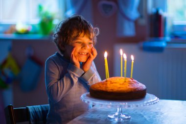 küçük çocuk çocuk pasta ve mumlar ile doğum gününü kutluyor