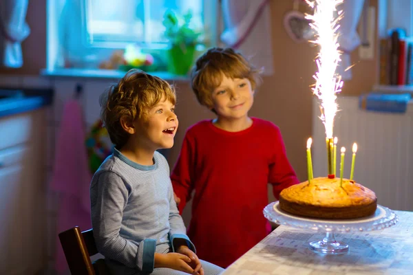 Kleine Jungen feiern Geburtstag und pusten Kerzen auf Kuchen — Stockfoto