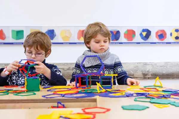 Två kid lite pojkar bygga geometriska figurer — Stockfoto