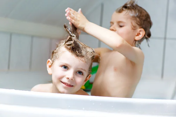Два маленьких мальчика играют вместе в ванной — стоковое фото
