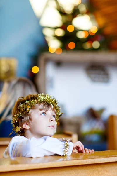 Kleiner Junge spielt Weihnachtsengel in der Kirche — Stockfoto