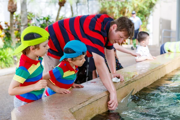 Teacher and two little kid boys feeding rays in a recreation are — Stock Photo, Image