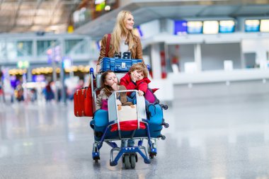 Küçük kız ve çocuk ve genç anne ile bavul Havaalanı