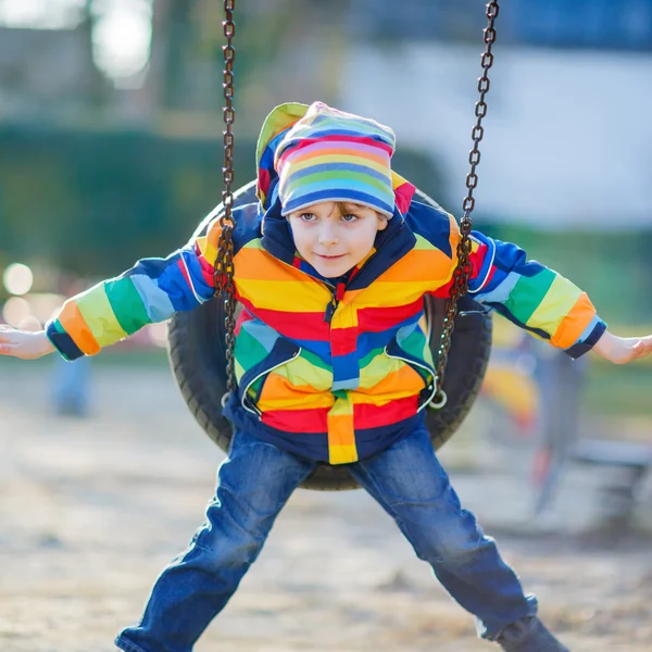 Petit garçon s'amuser sur la chaîne swing à l'extérieur — Photo