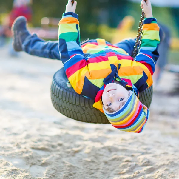 Little kid boy swinging on playground outdoors — Stock Photo, Image