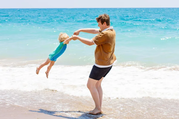 Padre e piccolo bambino ragazzo avendo divertimento su spiaggia — Foto Stock