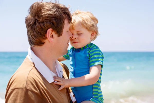 Pai e pequeno menino se divertindo na praia — Fotografia de Stock