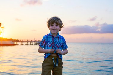 Küçük çocuk çocuk Okyanusu yakın gün batımında