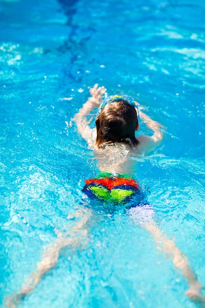 Маленький мальчик учится плавать в бассейне — стоковое фото