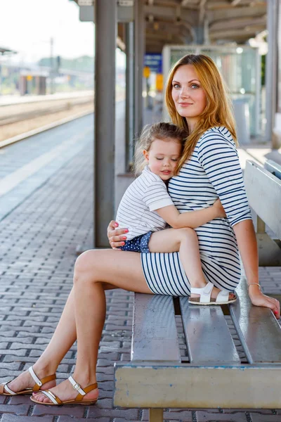 Roztomilá holčička a matka na železniční stanici. — Stock fotografie