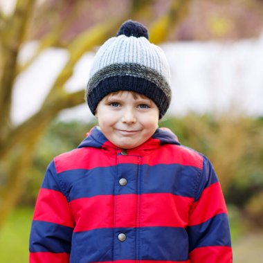 Kid boy in bright colorful clothes outdoors