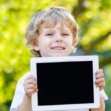 tablet pc, açık havada tutan gülümseyerek mutlu küçük çocuk