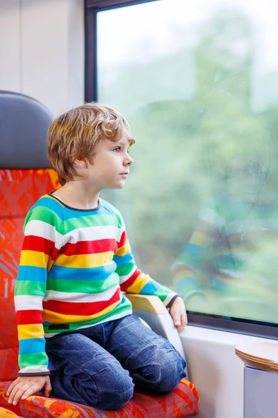 Little boy sitting in train and going on vacations — Stok fotoğraf