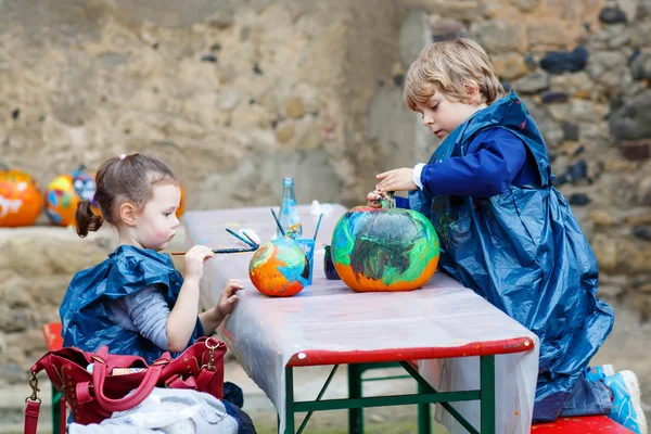Menino e menina pintura com cores na abóbora — Fotografia de Stock