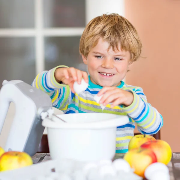 Divertente ragazzo biondo che cuoce torta di mele al chiuso — Foto Stock