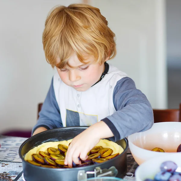 Adorable little boy helping and baking plum pie — Stock Photo, Image
