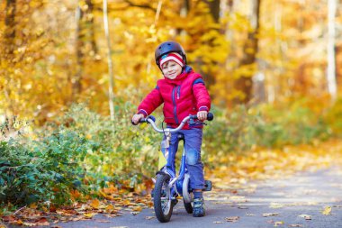 Küçük çocuk çocuk sonbahar ormandaki bisiklet ile