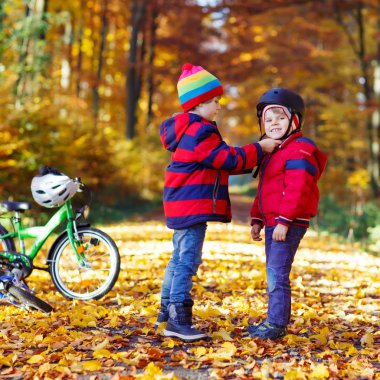 İki küçük çocuklar sonbahar ormandaki bisiklet ile çocuk