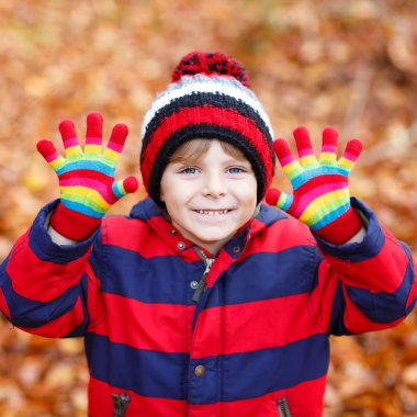 Sonbahar yaprakları arasında küçük şirin bir çocuk parkta..