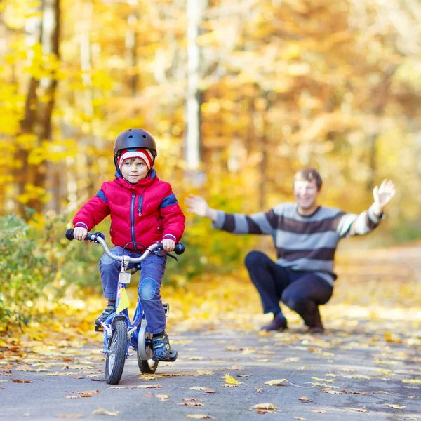 少しのキッド少年と秋の森で自転車と父 — ストック写真